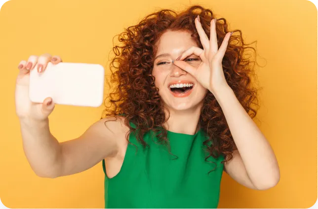 Uśmiechnięta kobieta trzymająca telefon